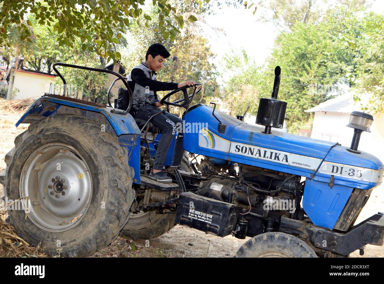 Garçon prétendant conduire un tracteur Banque D'Images