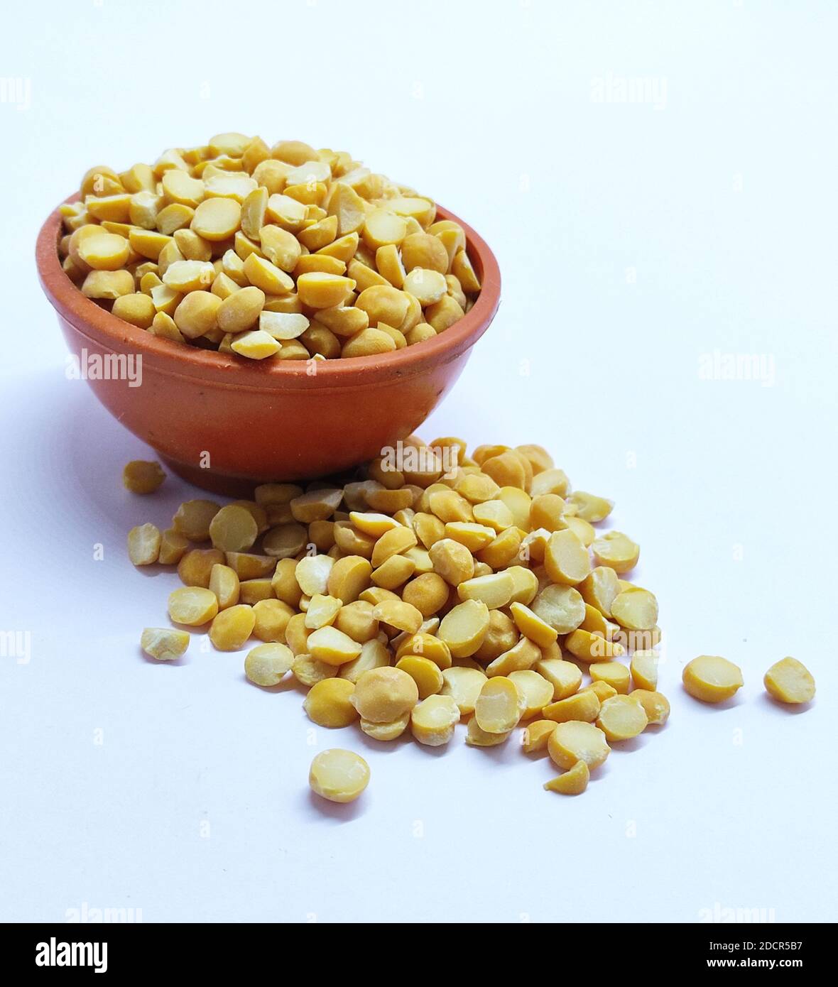 Lentille jaune dans un bol isolée sur fond blanc avec un chemin de coupure. Pour préparer une soupe traditionnelle indienne épicée et une purée de chana dal. Banque D'Images