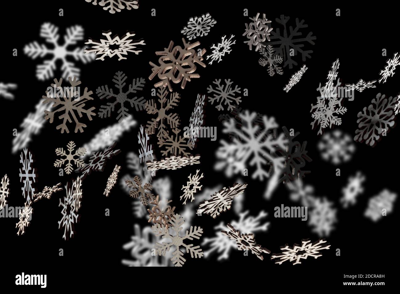 Des flocons de neige élégants tombent sur un fond noir pour Noël. Décoration motif hiver Banque D'Images