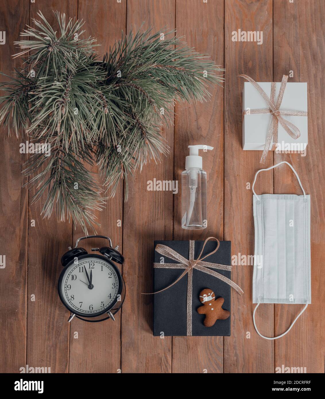 Composition commerciale de Noël. Cadeaux, décorations noires et dorées sur fond de bois. Espace de travail, cookies sous la forme d'un homme dans un masque. Vacances c Banque D'Images