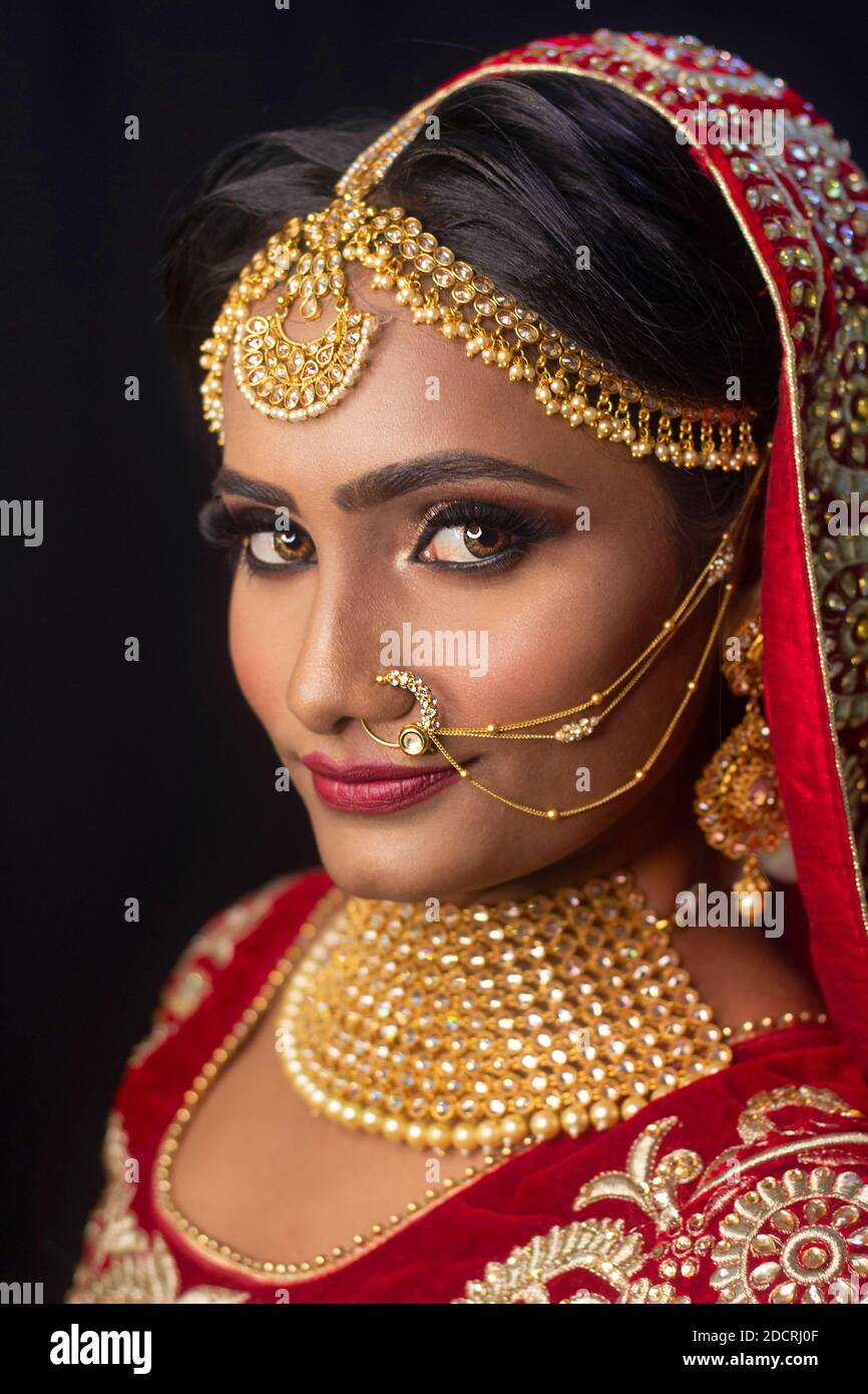 Jeune femme indienne attrayante modèle habillé en costume traditionnel  indien lehenga choli avec des bijoux de style Kundan. Regarder vers le bas.  Arrière-plan noir Photo Stock - Alamy