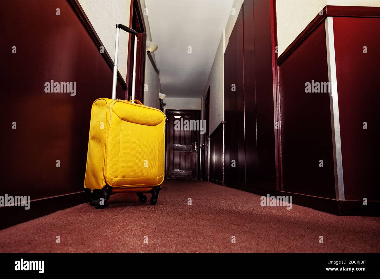 Valise jaune près de la porte de la chambre dans le hall de le concept hôtel - voyage Banque D'Images