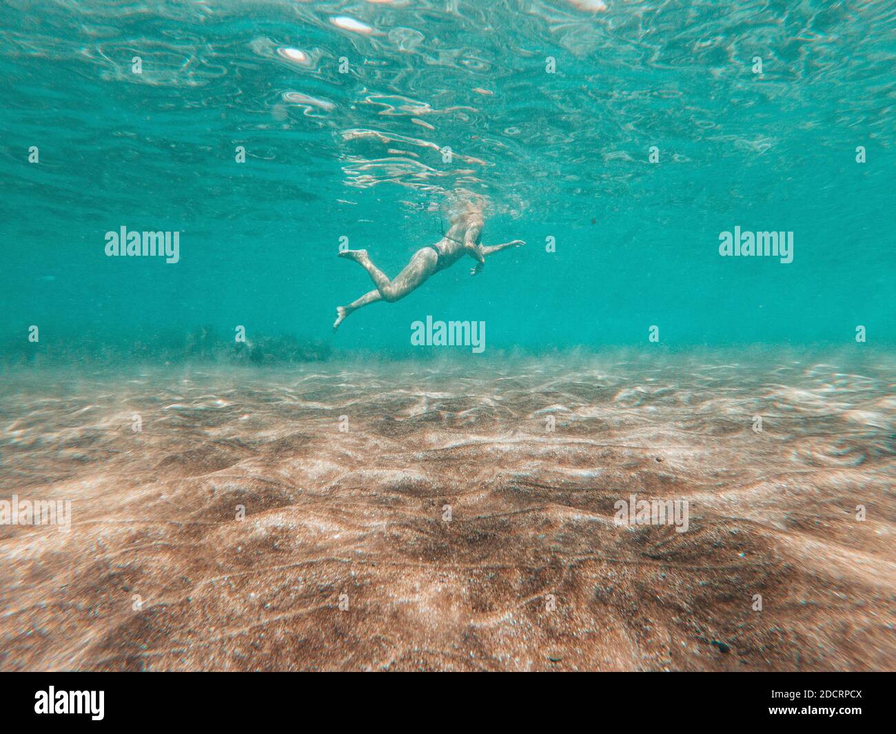 Vue sous-marine dans bleu mer océan eau de la femme active natation et profiter des vacances d'été à la plage Banque D'Images