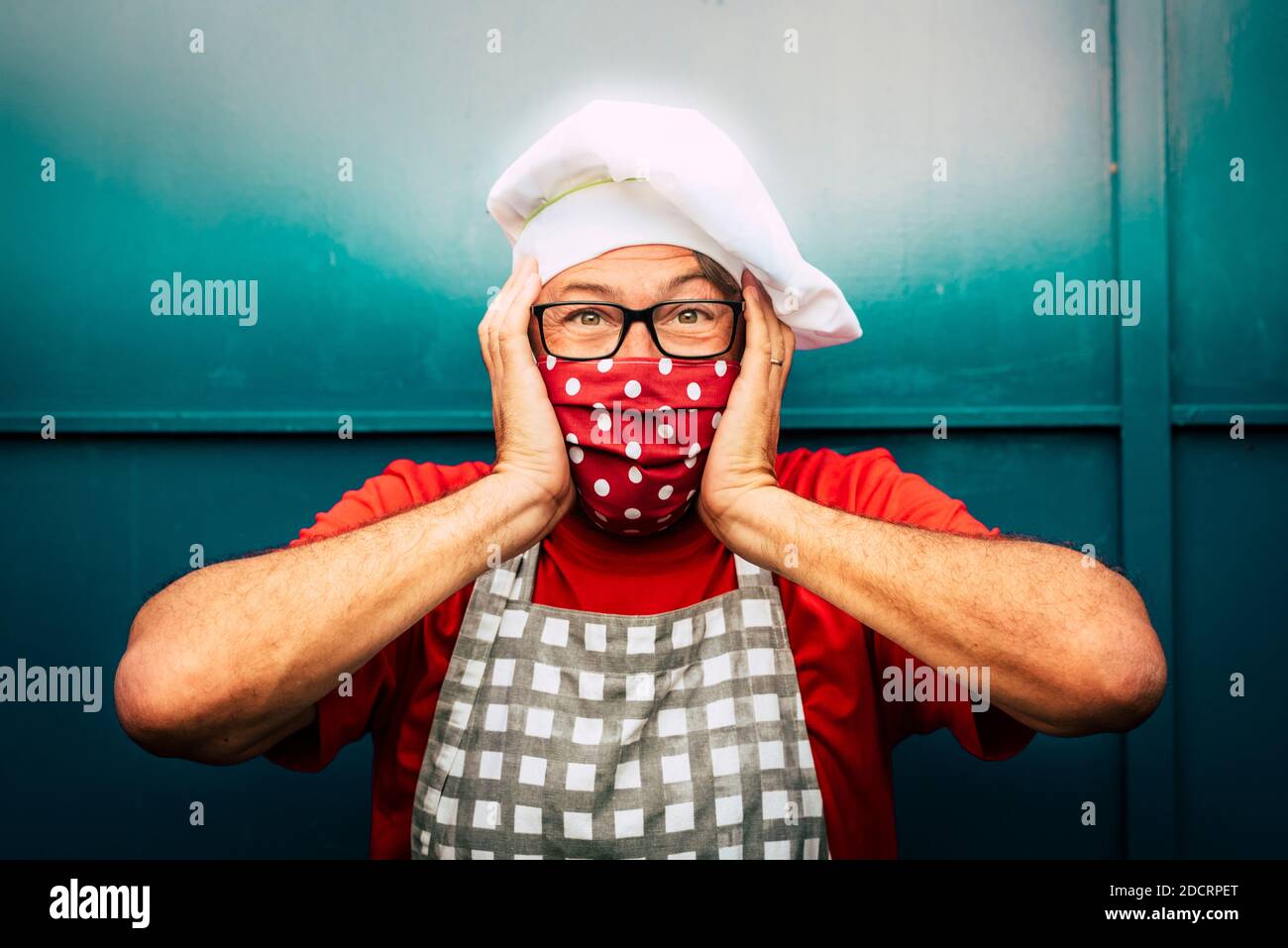 Portrait d'un homme adulte souriant avec chapeau de père noël rouge et masque facial pour l'urgence du coronavirus covid-19 virus - concept de noël et holi Banque D'Images