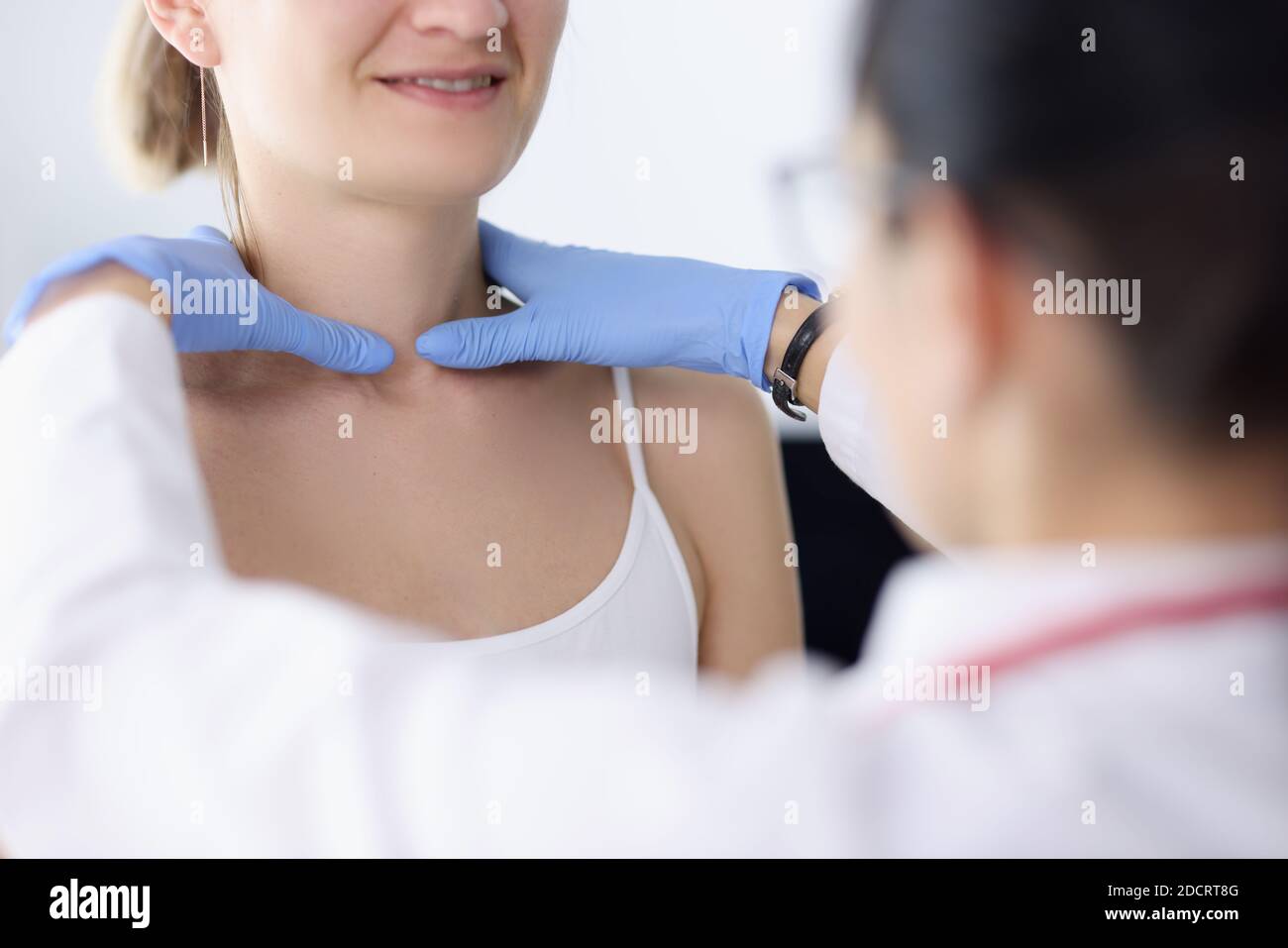 Le médecin examine la proximité de la glande thyroïde du patient Banque D'Images