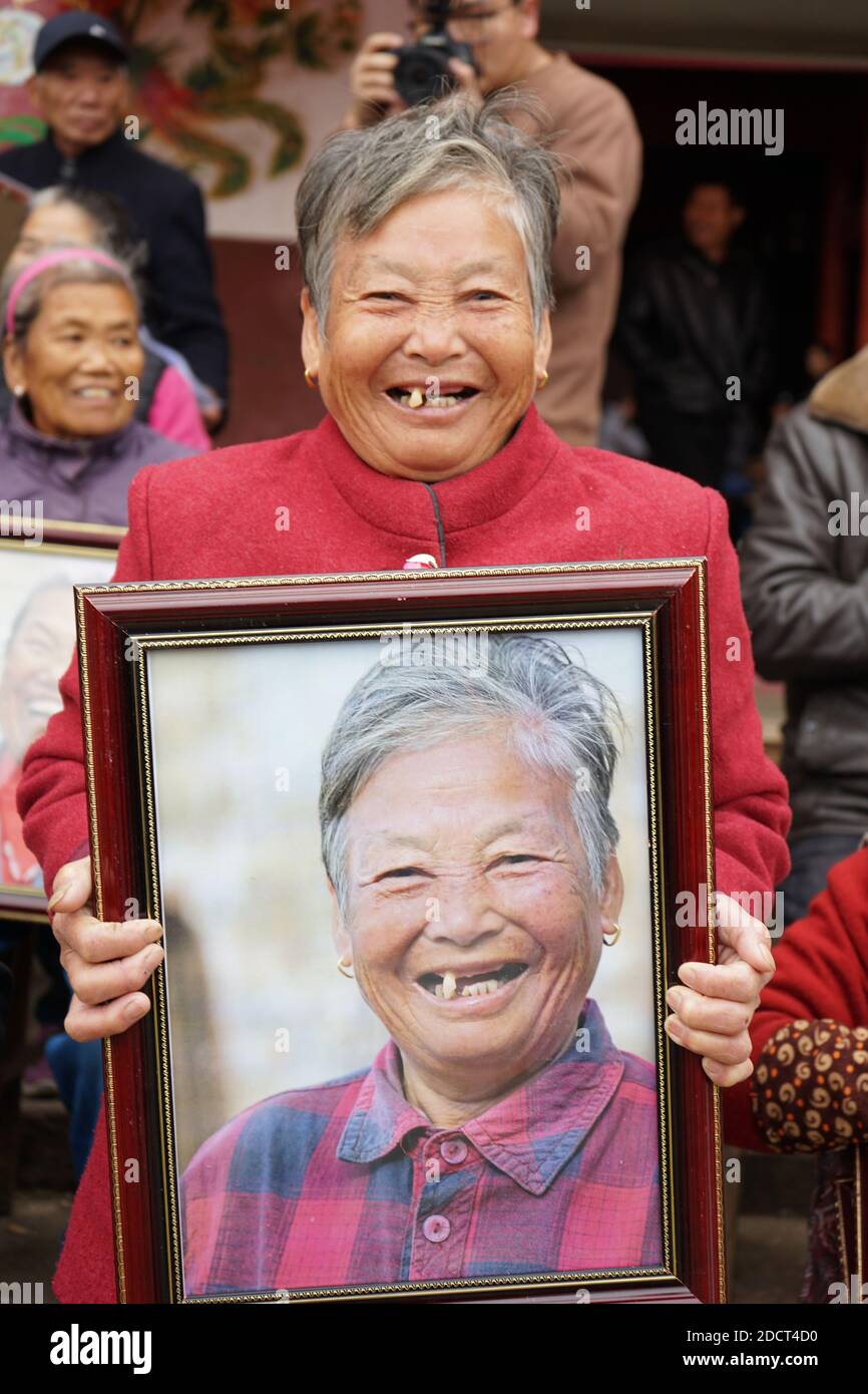 (201123) -- NANCHANG, 23 novembre 2020 (Xinhua) -- UN villageois sourit en montrant sa photo dans le village de Xiawei, dans la ville de Youlan, dans le comté de Nanchang, dans la province de Jiangxi, en Chine orientale, le 22 novembre 2020. Depuis 2014, des bénévoles d'une organisation à but non lucratif de Nanchang City ont continué à prendre des photos de visages souriants de fermiers âgés de plus de 70 ans dans des villages voisins. Les photos de portait prises par des bénévoles ont été données gratuitement aux agriculteurs. De loin, les volontaires ont pris près de 4,350 personnes et 50,000 photos. Ils visent à recueillir des images haute définition de 10,000 agriculteurs dans un délai de 10 ans. (Xinhua/Chen Chun Banque D'Images