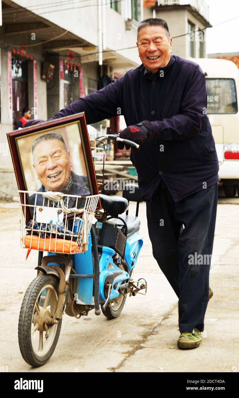 (201123) -- NANCHANG, 23 novembre 2020 (Xinhua) -- UN villageois rentre chez lui avec sa photo dans le village de Xiawei, dans la ville de Youlan, dans la ville de Nanchang, dans la province de Jiangxi, en Chine orientale, le 22 novembre 2020. Depuis 2014, des bénévoles d'une organisation à but non lucratif de Nanchang City ont continué à prendre des photos de visages souriants de fermiers âgés de plus de 70 ans dans des villages voisins. Les photos de portait prises par des bénévoles ont été données gratuitement aux agriculteurs. De loin, les volontaires ont pris près de 4,350 personnes et 50,000 photos. Ils visent à recueillir des images haute définition de 10,000 agriculteurs dans un délai de 10 ans. (Xinhua/Chen Chunyuan) Banque D'Images