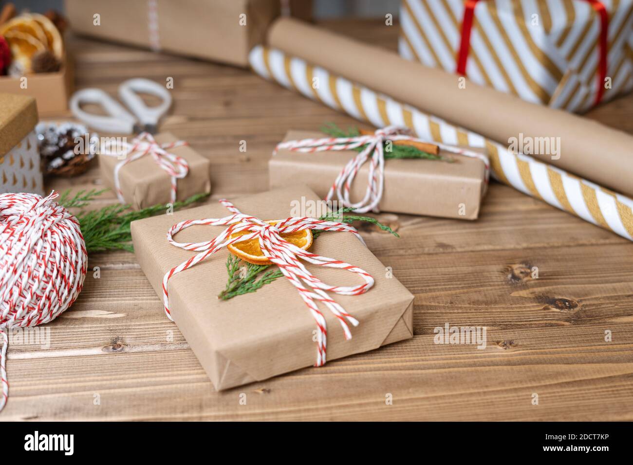 Emballage cadeau de Noël, gros plan. Cadeaux non préparés sur fond de bois  avec orange, cannelle, ruban, ciseaux, branche d'épicéa, éléments de décor  et Photo Stock - Alamy