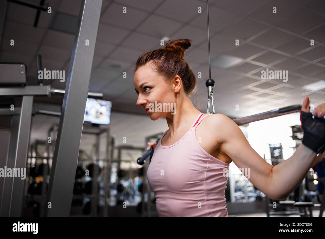 Jeune femme sur la télécabine dans la salle de gym Banque D'Images