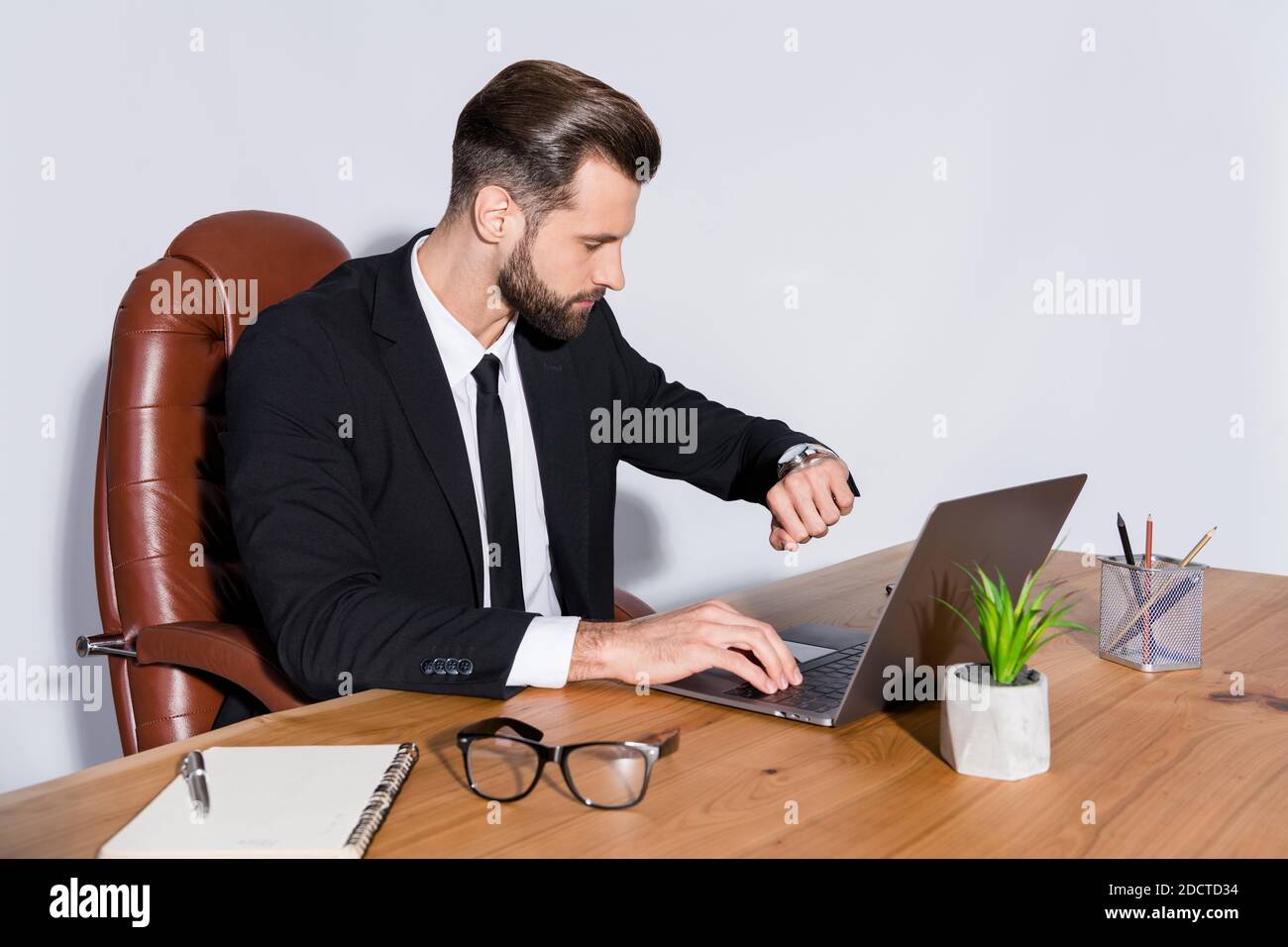 Quelle heure est-il photo de profil de beau homme d'affaires bloc-notes  travail de table heures supplémentaires vérifier temps montres main porter  blazer chemise cravate costume chaise assise Photo Stock - Alamy