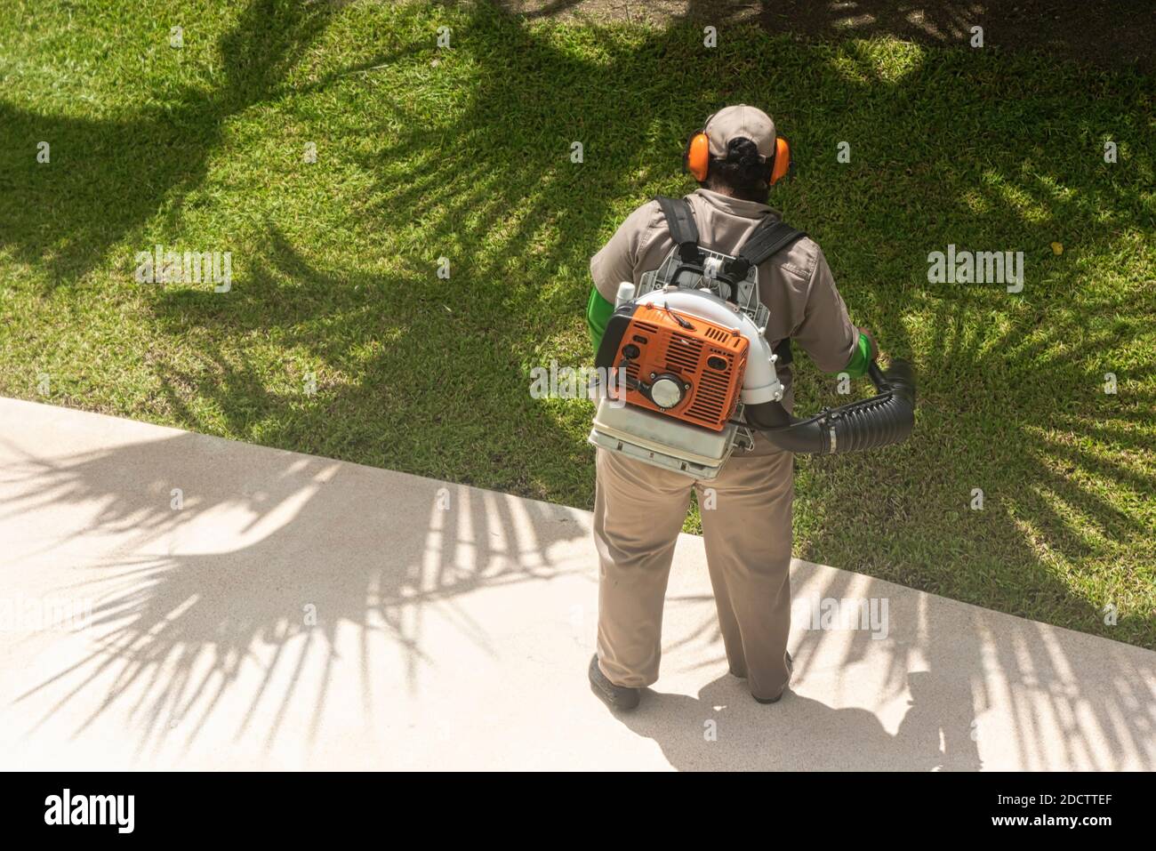 Vue arrière d'un homme inconnu travaillant dans le jardin avec un souffleur d'épaule. Mexique Banque D'Images