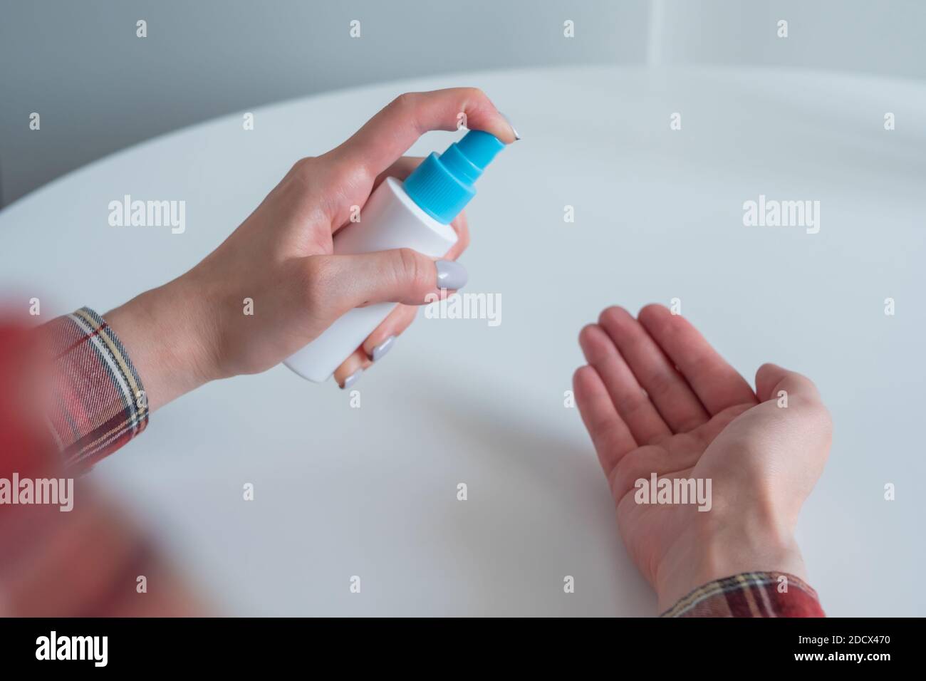 Femme pulvérisant un antiseptique sur les mains - gros plan - pulvérisation désinfection Banque D'Images