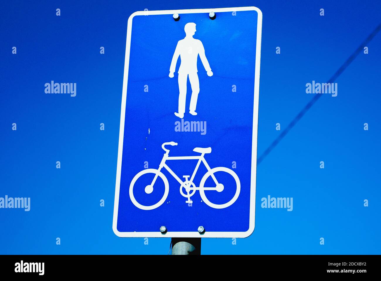 Signe carré blanc et bleu pour la piste piétonne et cyclable. Ciel bleu en arrière-plan. Banque D'Images