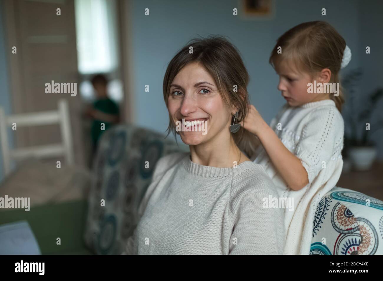 La fille brase les cheveux de sa mère. Ameublement intérieur. Banque D'Images