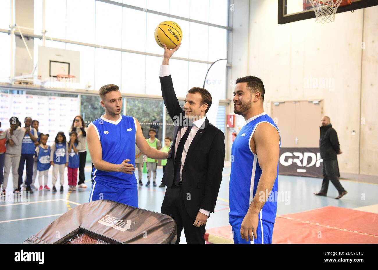 Le président français Emmanuel Macron observe les enfants s'entraîner au  basket-ball lors d'une visite au gymnase Jesse Owens à Villetaneuse, près  de Seine-Saint-Denis, au nord de la capitale, où il a rencontré