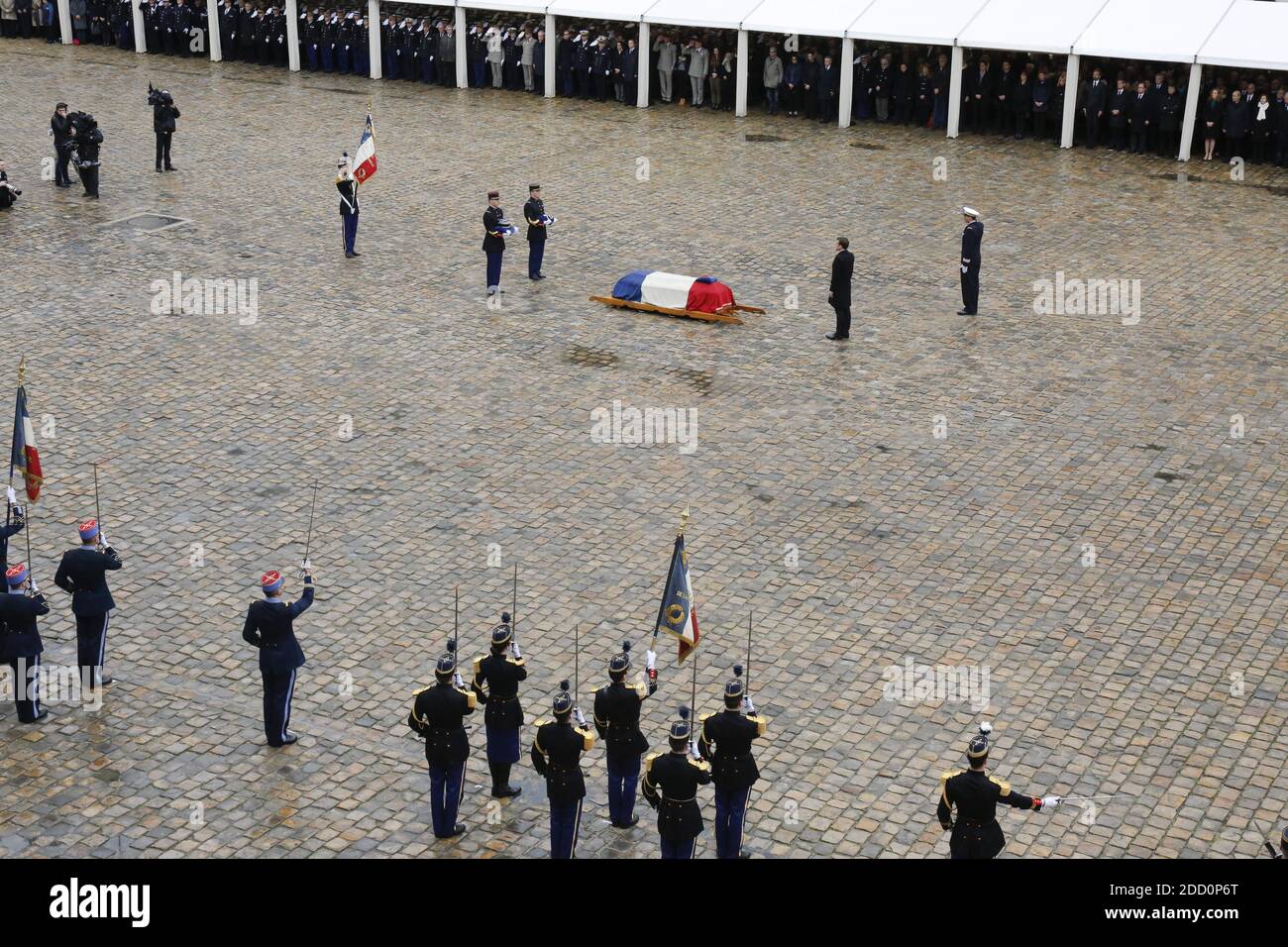 Le président français Emmanuel Macron marche devant le cercueil à drapeau du lieutenant-colonel Arnaud Beltrame après l'avoir décerné à titre posthume à la Légion d'honneur lors d'une cérémonie nationale pour le lieutenant-colonel Arnaud Beltrame, le 28 mars 2018 à l'Hôtel des Invalides à Paris, en France. La France honore lors d'une cérémonie nationale le 28 mars un policier héroïque qui est mort en se proposant comme otage dans une attaque djihadiste. Beltrame, 44 ans, a été la quatrième et dernière victime de la fusillade du 23 mars dans les villes du sud-ouest de Carcassonne et de Trebes. Photo d'Henri Szwa Banque D'Images