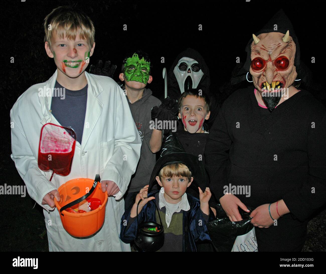 Enfants sur Hallowe'en, cinq garçons et une fille. De quatre à quatorze ans, trick ou traiter. Banque D'Images