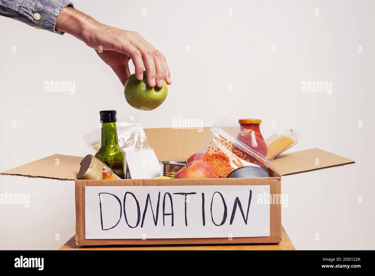 Homme mettant une agrafe dans une boîte pleine sur en boîte et des aliments emballés Banque D'Images