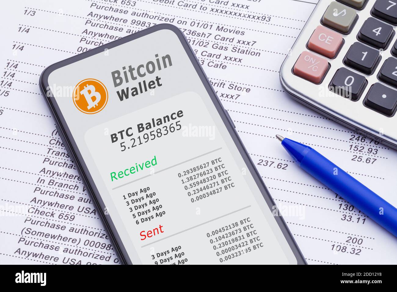 Smartphone avec portefeuille Bitcoin sur relevé bancaire avec calculatrice et stylo. Banque D'Images