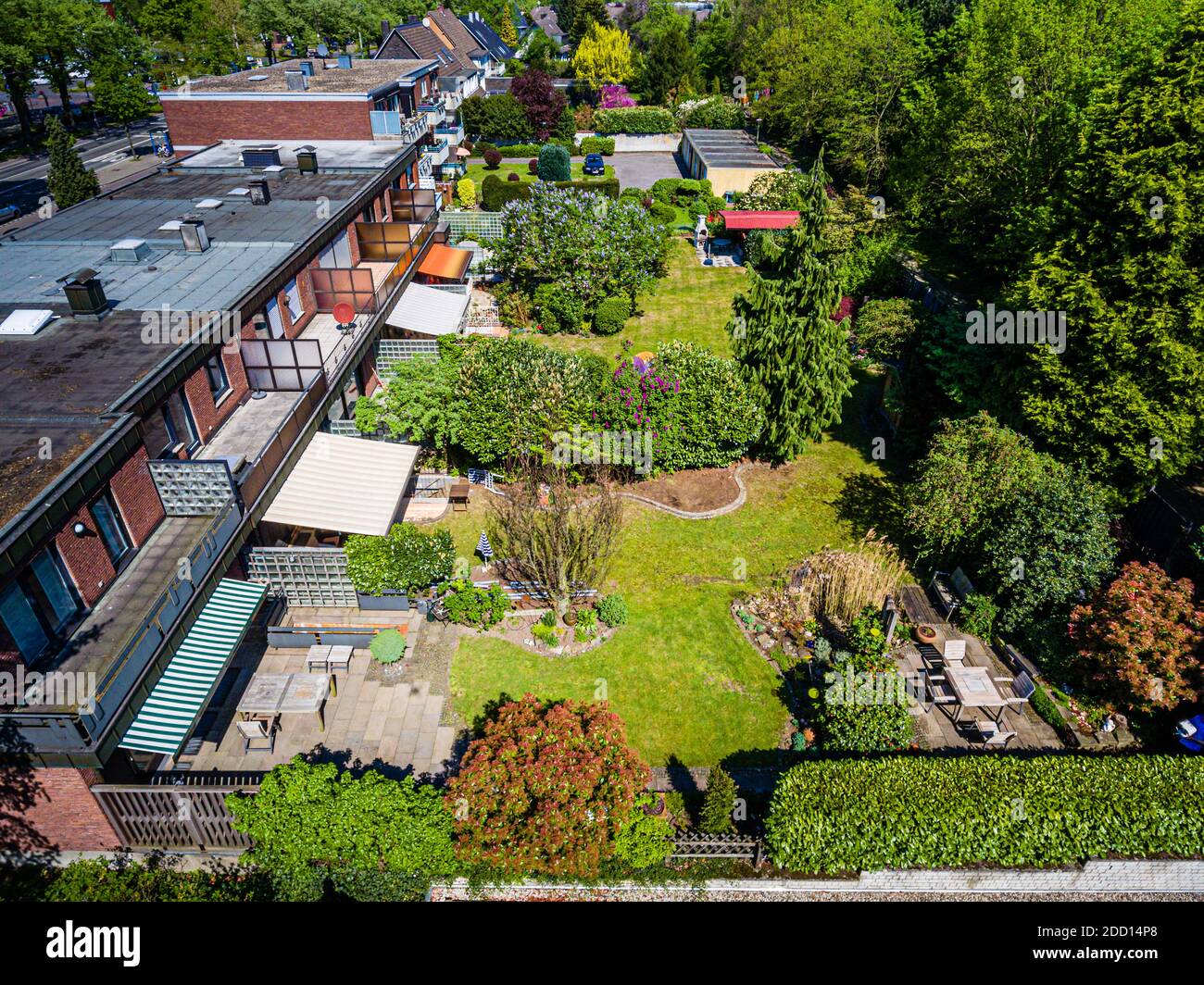 Une vue aérienne montre des maisons en rangée typiquement allemandes avec leurs jardins attenants à Bottrop, en Allemagne. Des terrasses, des pelouses et des brise-vues s'alignent les uns derrière les autres derrière les maisons. Banque D'Images