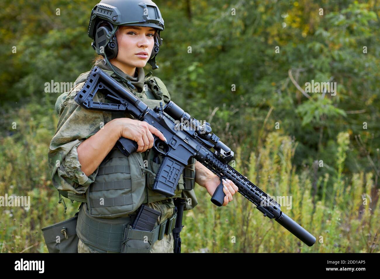 portrait d'une femme militaire confiante avec un fusil en forêt, chasseur femelle en costume de camouflage avec un fusil stand dans la nature seule Banque D'Images