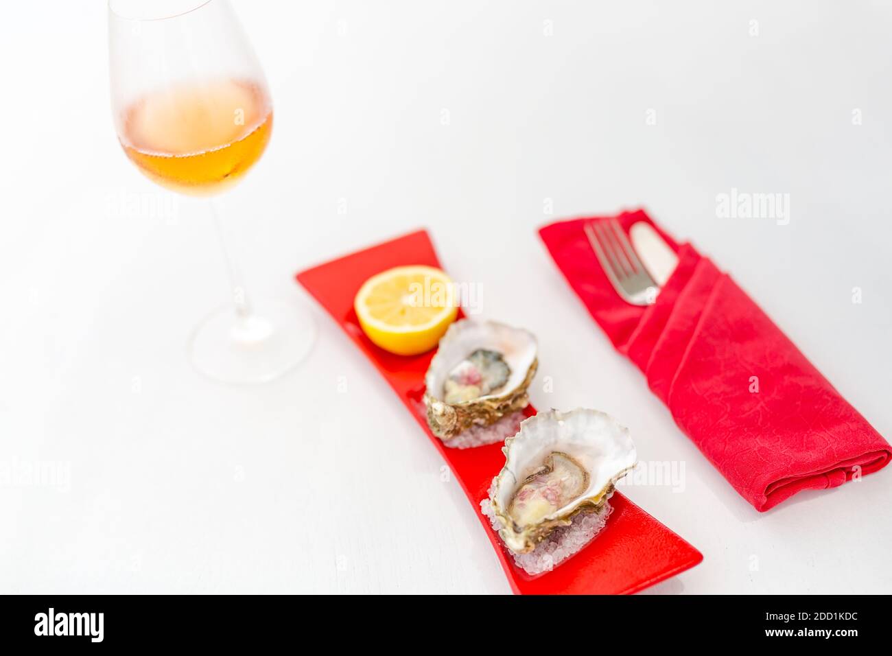 Huîtres fraîches en gros plan sur une assiette bleue, table servie avec des huîtres, du citron et de la glace. Alimentation saine en mer. Dîner aux huîtres fraîches au restaurant. Cuisine gastronomique. Banque D'Images