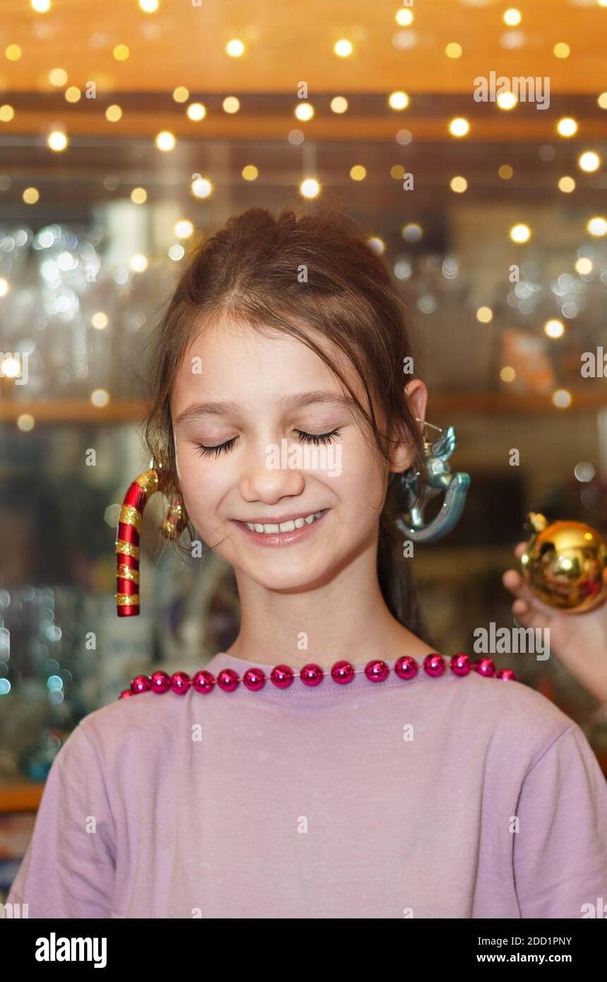Portrait d'une petite fille avec des yeux fermés et un Sourire rêveur en attente de Noël Banque D'Images