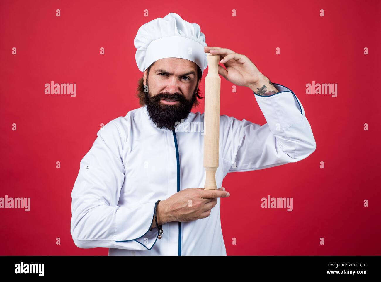 un homme de chef confiant avec une barbe et une moustache en uniforme de  cuisinier tient la goupille roulante, l'ustensile de cuisine Photo Stock -  Alamy