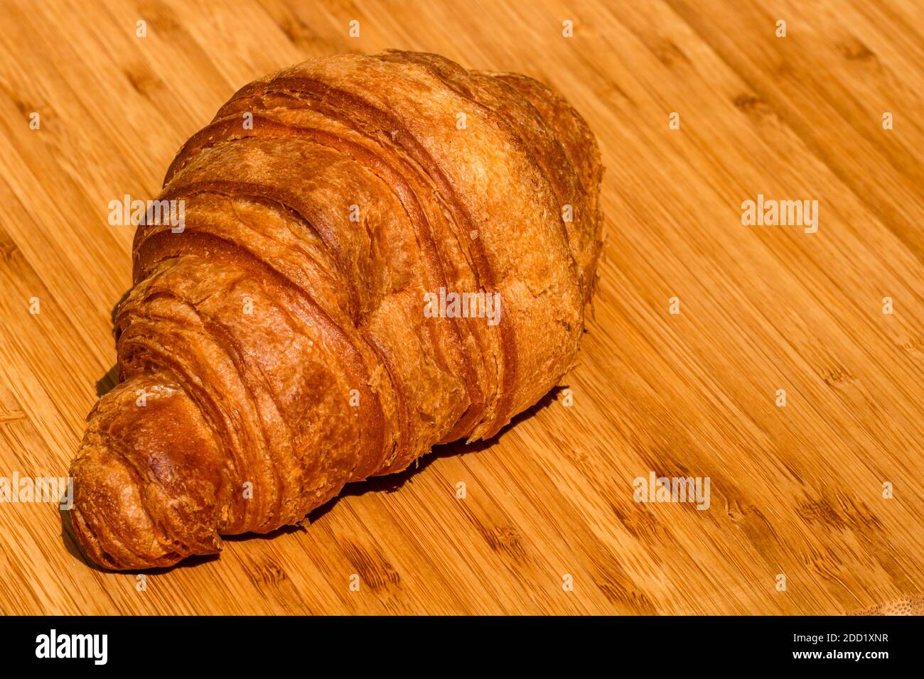 Détail croissant frais sur table en bois. Concept de restauration et petit déjeuner. Gros plan photo du croissant du beurre français Banque D'Images