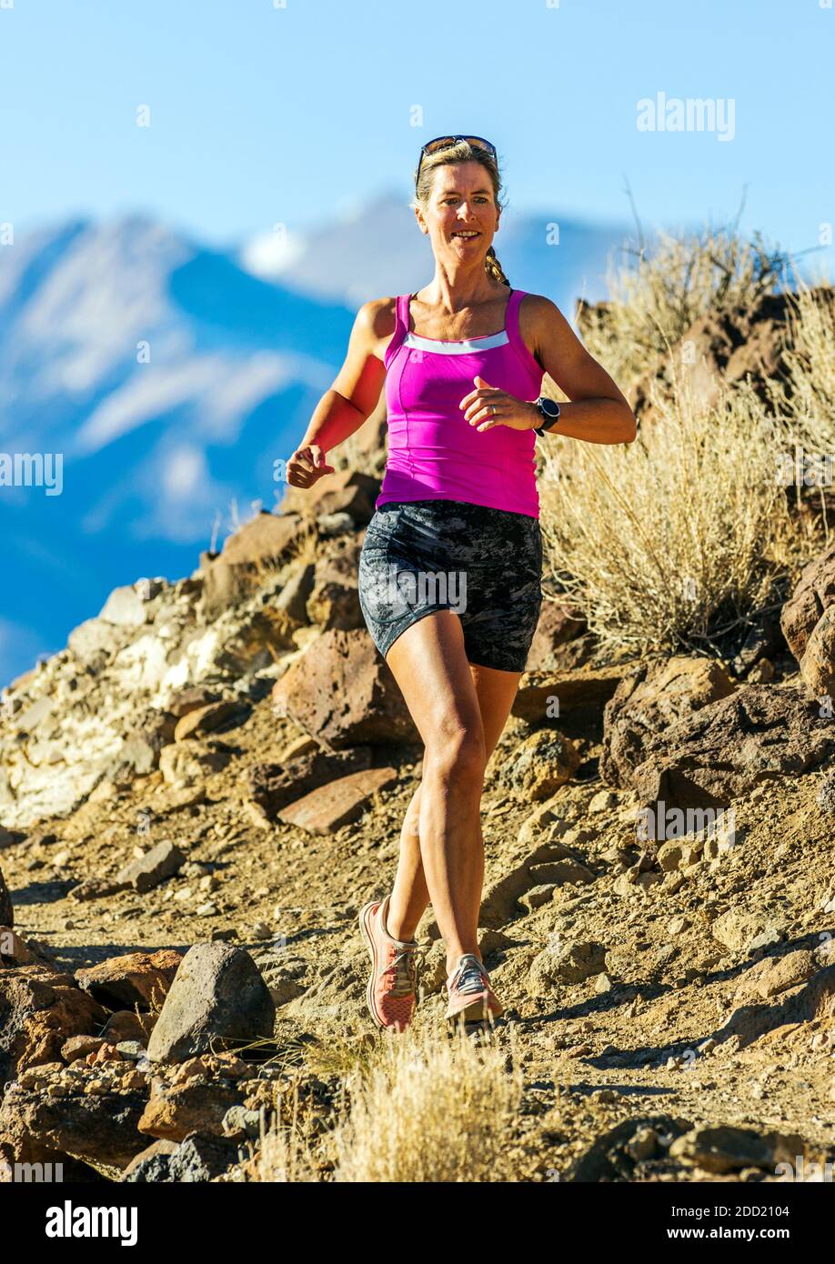 Femme d'âge moyen et attrayante qui court sur les sentiers de montagne ; Salida ; Colorado ; États-Unis Banque D'Images