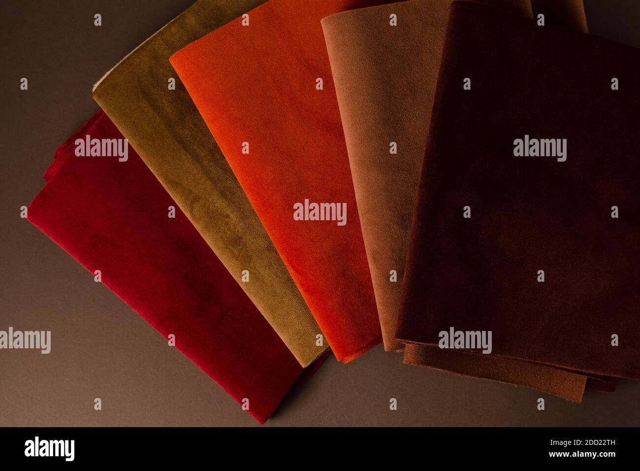 Une collection d'échantillons de textiles en velours rouge, marron et orange colorés. Arrière-plan de texture de tissu Banque D'Images