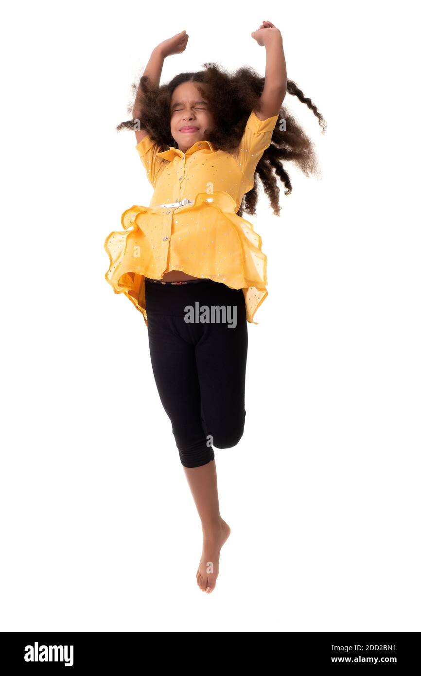 Petite fille multiraciale sautant avec ses yeux fermés et un Drôle d'expression - isolé sur un fond blanc Banque D'Images