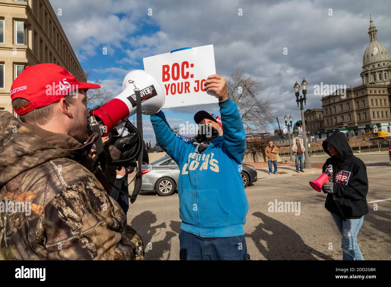 Lansing, Michigan, États-Unis. 23 novembre 2020. Un partisan du président élu Joe Biden (sweat-shirt bleu) et du président Donald Trump se sont engagés dans un match criant alors que les démarcheurs du Michigan Board of State se sont réunis pour décider s'il faut certifier les résultats de l'élection présidentielle de 2020. Le Conseil a ensuite certifié les résultats, qui ont montré Biden devant le président Trump par environ 150,000 voix. Crédit : Jim West/Alay Live News Banque D'Images