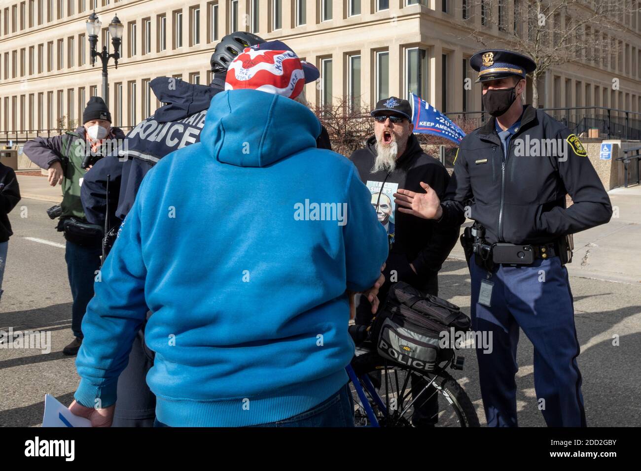 Lansing, Michigan, États-Unis. 23 novembre 2020. Un partisan du président élu Joe Biden (sweat-shirt bleu) et du président Donald Trump se sont engagés dans un match criant alors que les démarcheurs du Michigan Board of State se sont réunis pour décider s'il faut certifier les résultats de l'élection présidentielle de 2020. La police est intervenue pour garder les deux à l'écart. Le Conseil a ensuite certifié les résultats, qui ont montré Biden devant le président Trump par environ 150,000 voix. Crédit : Jim West/Alay Live News Banque D'Images Lansing, Michigan, États-Unis. 23 novembre 2020. Un partisan du président élu Joe Biden (sweat-shirt bleu) et du président Donald Trump se sont engagés dans un match criant alors que les démarcheurs du Michigan Board of State se sont réunis pour décider s'il faut certifier les résultats de l'élection présidentielle de 2020. La police est intervenue pour garder les deux à l'écart. Le Conseil a ensuite certifié les résultats, qui ont montré Biden devant le président Trump par environ 150,000 voix. Crédit : Jim West/Alay Live News Banque D'Images