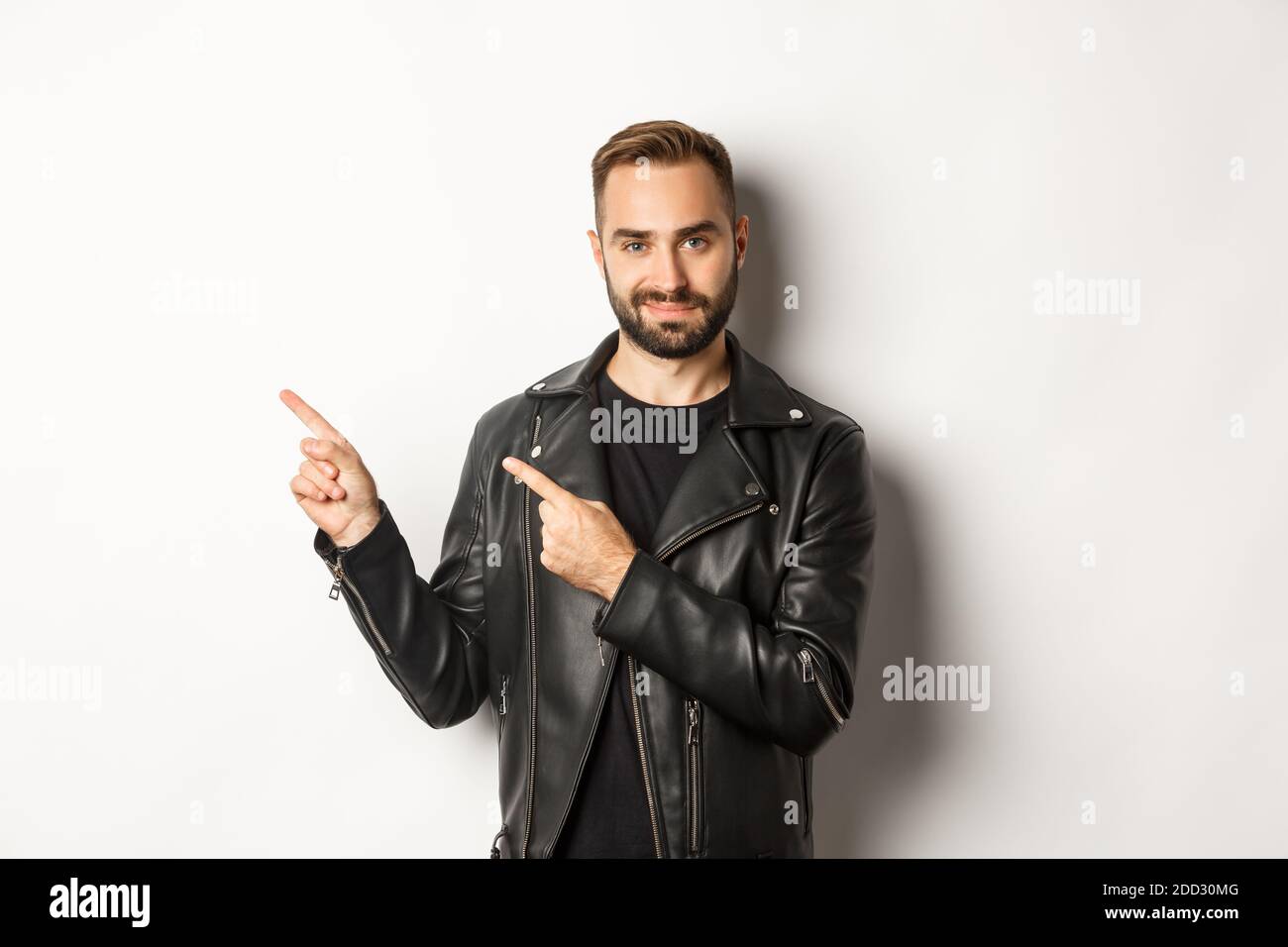 Homme macho confiant dans une veste en cuir noir, pointant les doigts à  gauche à l'offre promo, montrant le logo, fond blanc Photo Stock - Alamy