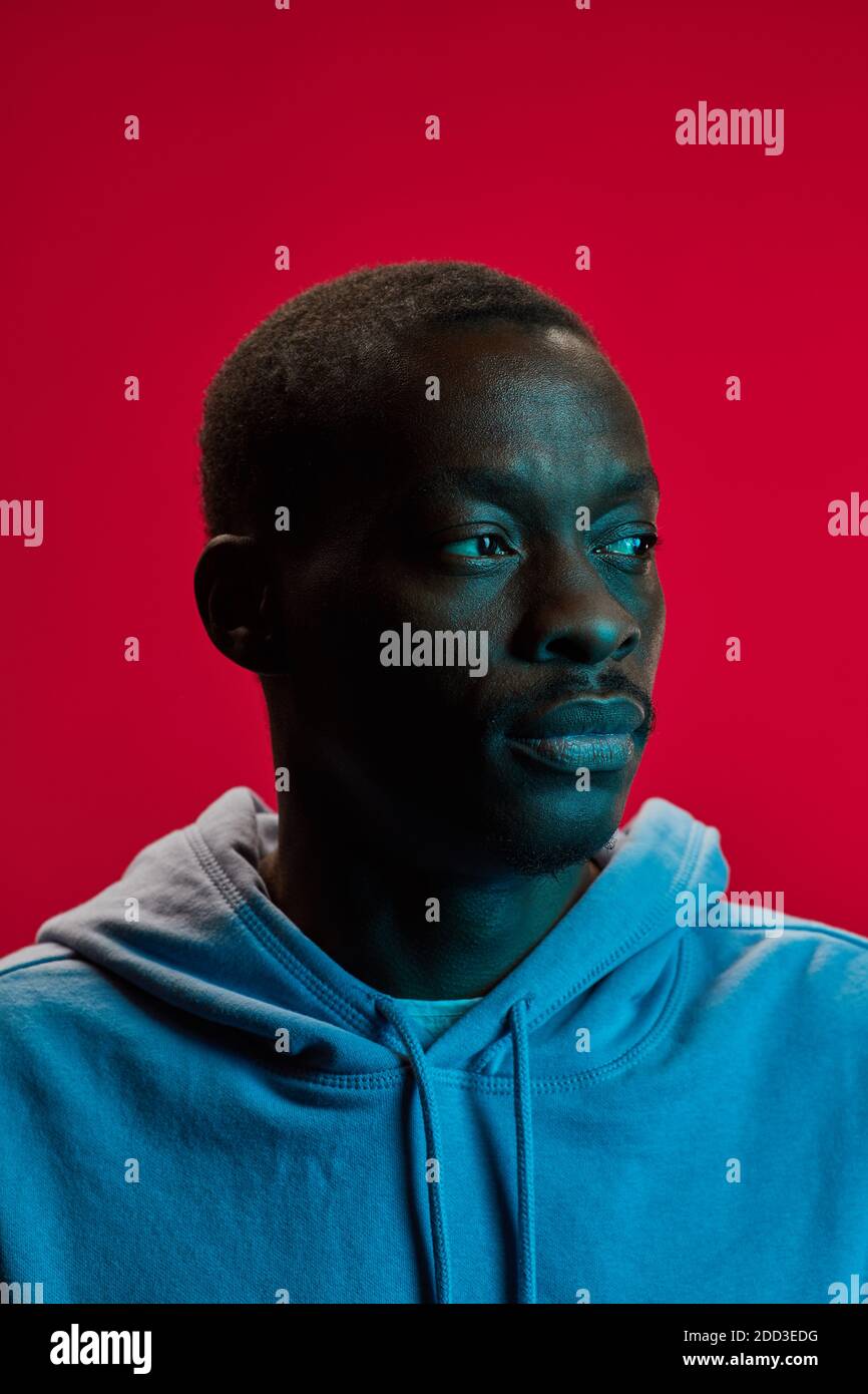 Portrait du jeune homme africain en sweat-shirt isolé sur rose arrière-plan Banque D'Images