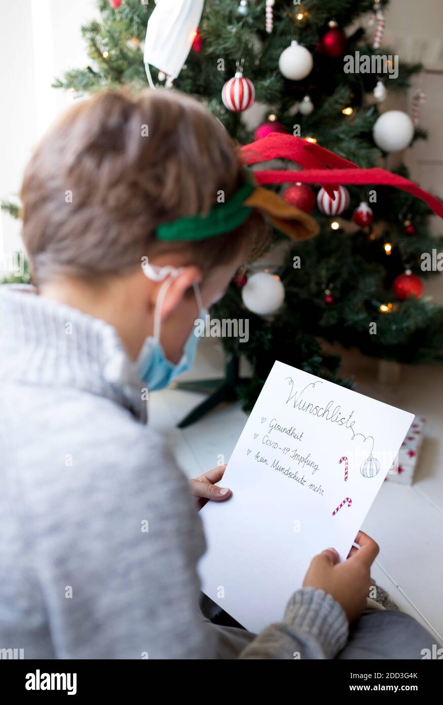 L'enfant écrit la liste de souhaits de Noël pendant la crise corona en isolement Banque D'Images