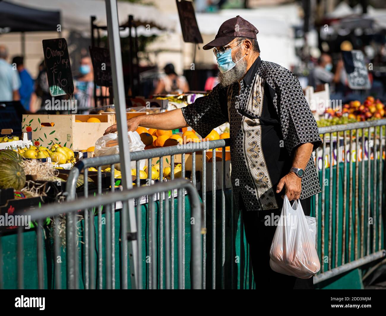 Chalon en Champagne, France - 07 août 2020 : homme avec masque facial achetant sur un marché par une chaude journée ensoleillée en été Banque D'Images