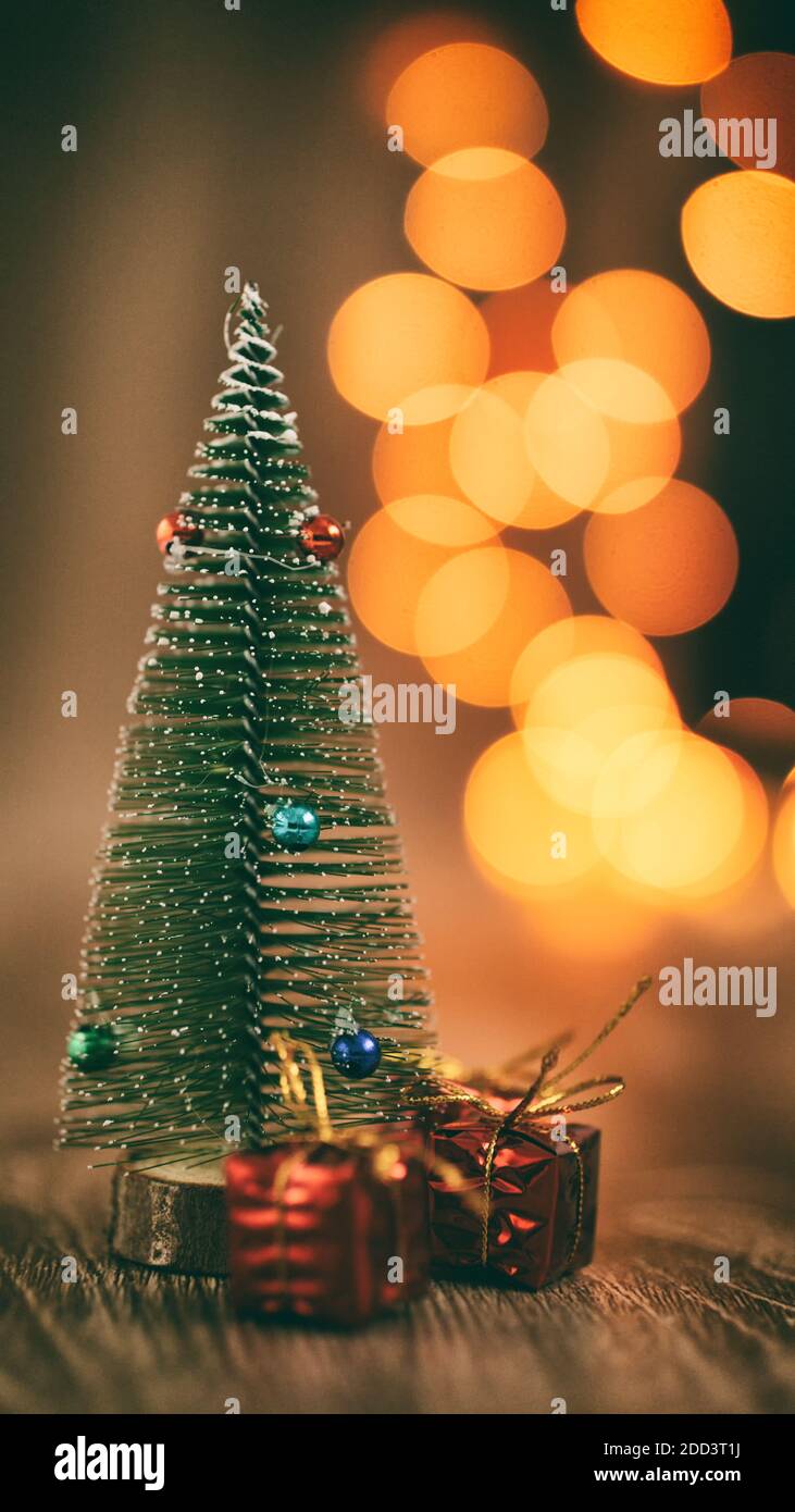 Décoration d'arbre de noël miniature avec cadeaux decors d'arbre miniature illuminations de noël scintillantes et floues, pour une ambiance de noël chaleureuse Banque D'Images