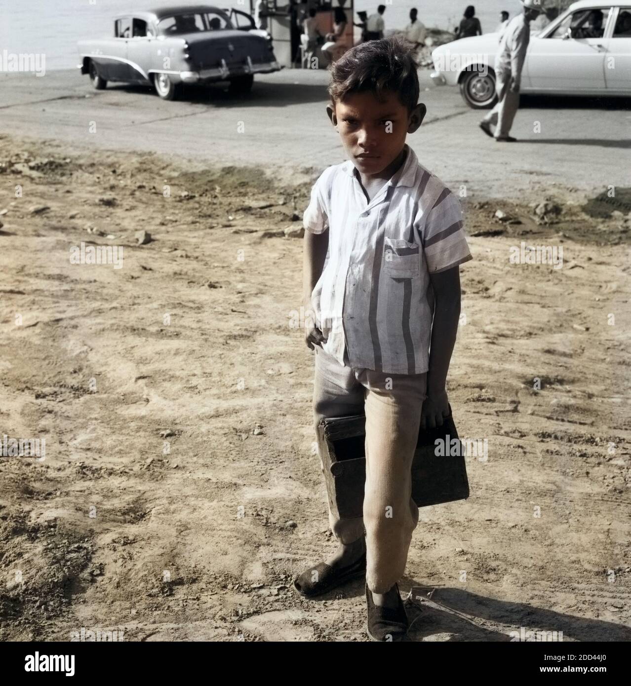 Junge Am Ufer vor automobiles, Venezuela 1966 : Garçon à la rive du fleuve en face de voitures, Venezuela 1966. Banque D'Images