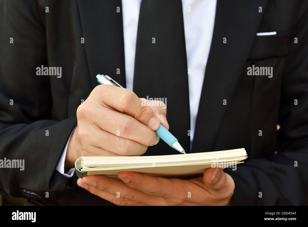 Gros plan de l'homme d'affaires qui écrit une note à l'entreprise document, contrat de signature, accord de partenariat. Banque D'Images