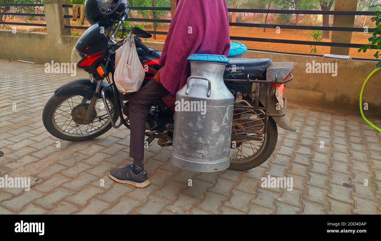 2020 novembre- Mahroli, Jaipur, Inde / Femme indienne rurale verser du lait dans la canne à lait le matin. Banque D'Images