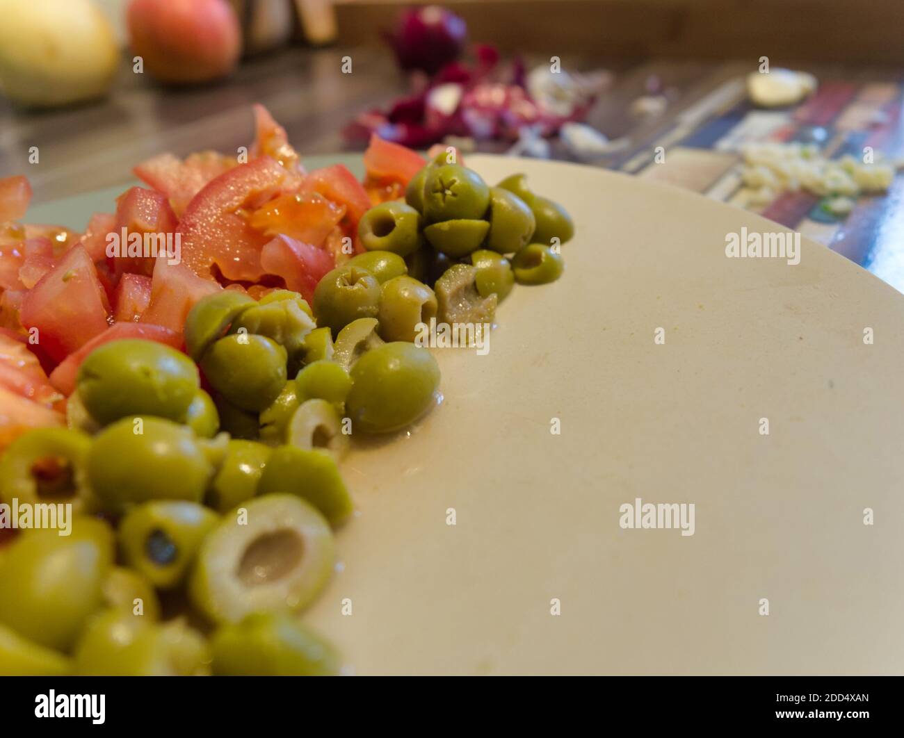 Préparation des tomates et de l'olive verte pour la salade Banque D'Images