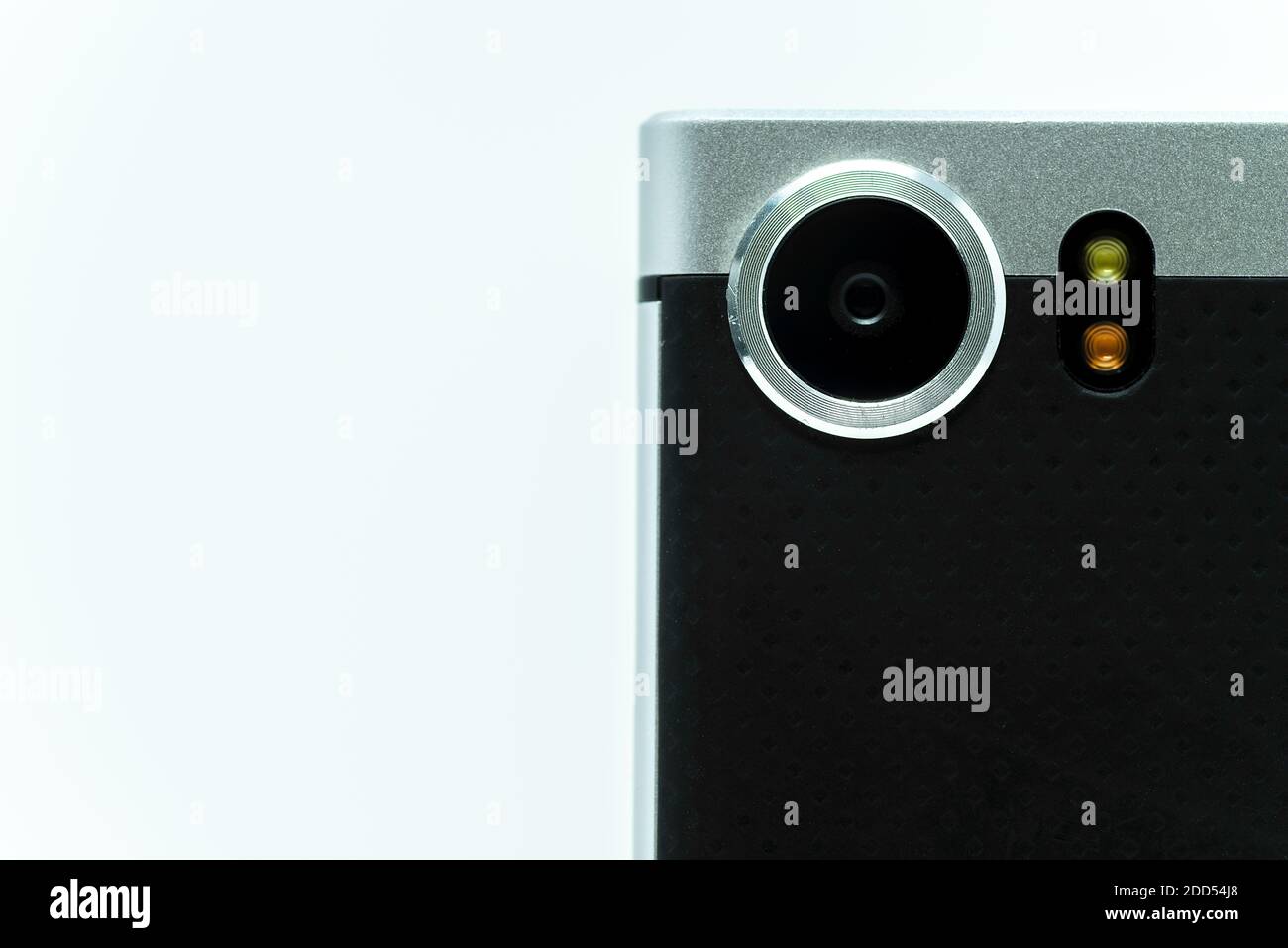 Gros plan de l'objectif de l'appareil photo du téléphone portable sur une simple arrière-plan blanc avec espace de copie Banque D'Images