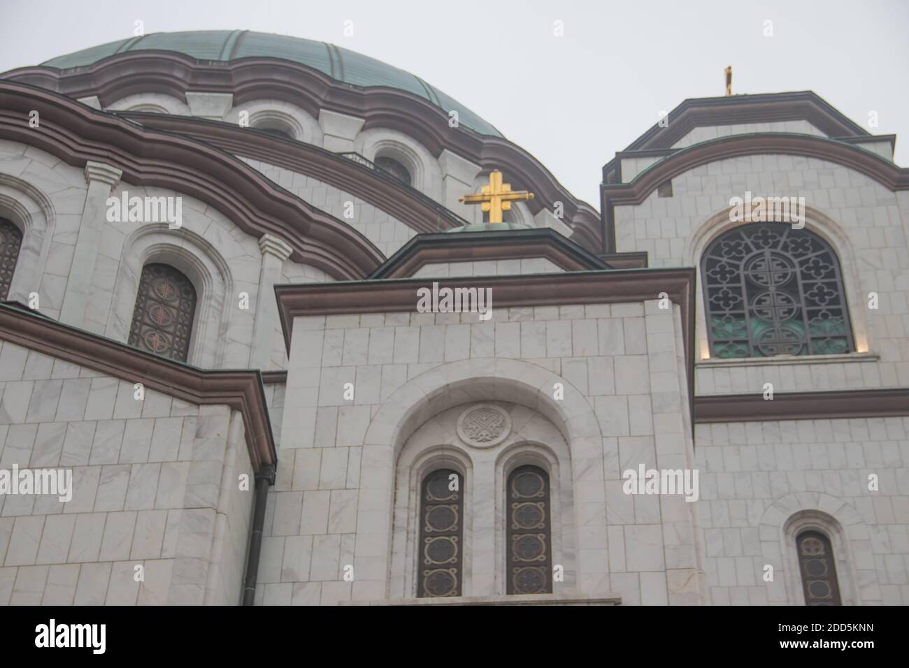 Détails du temple de Saint Sava (Hram Svetog Save, en serbe), fenêtres et coupole avec croix dorée sur le dessus, puissants murs blancs. Banque D'Images