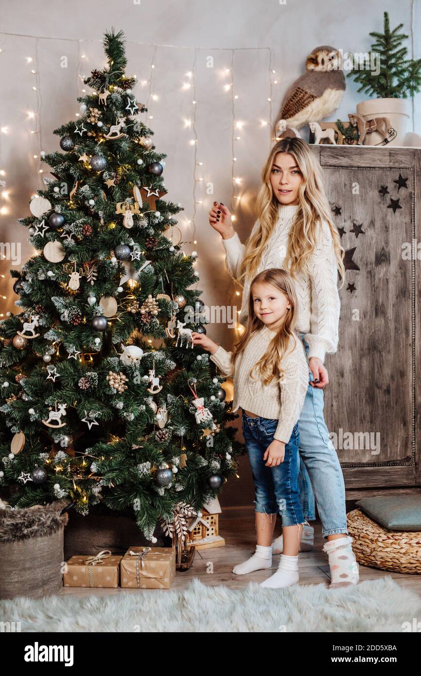 Petite fille et sa mère décorent un arbre de Noël pour Nouvelle année Banque D'Images