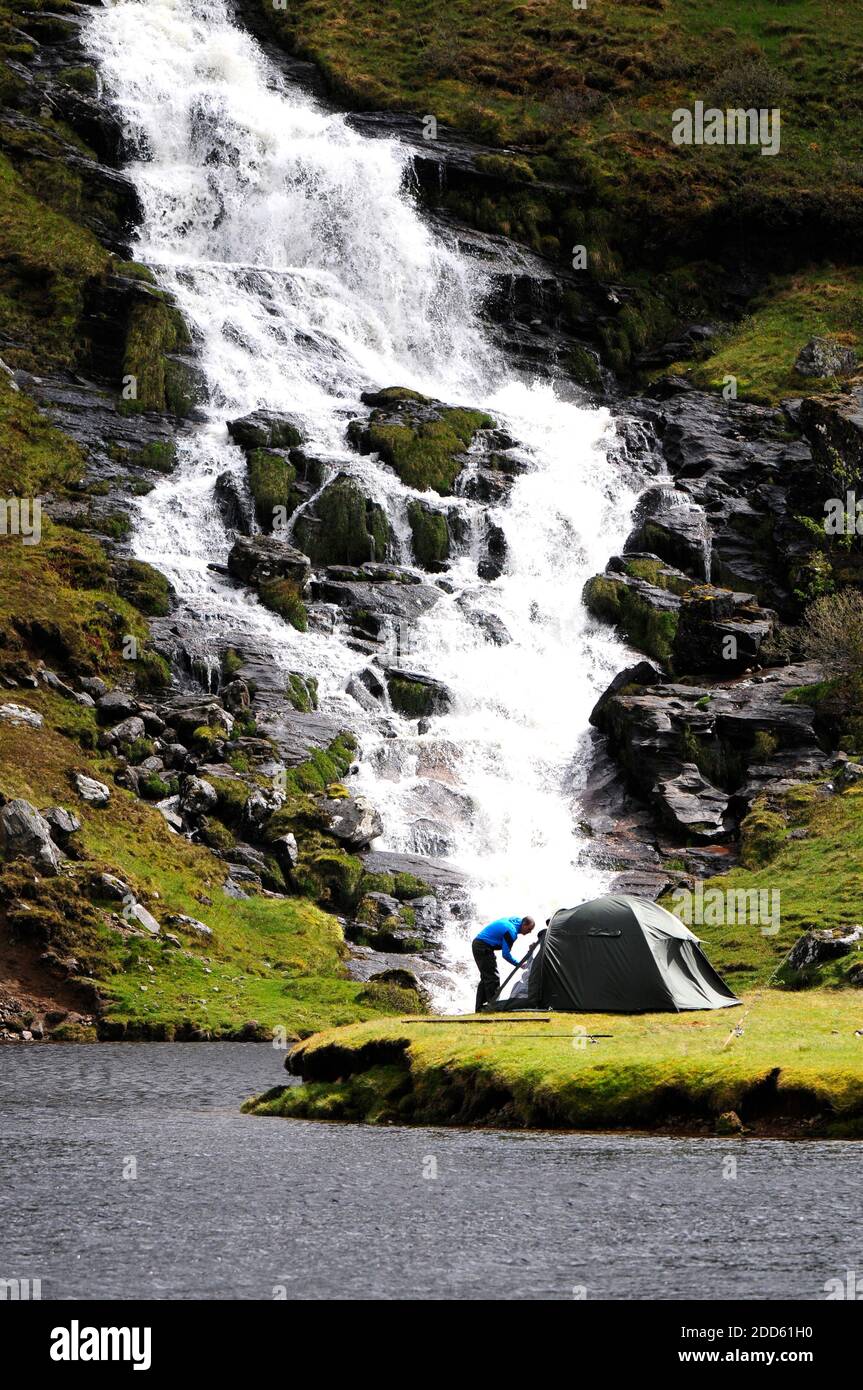 Campeur près d'une cascade pittoresque Banque D'Images