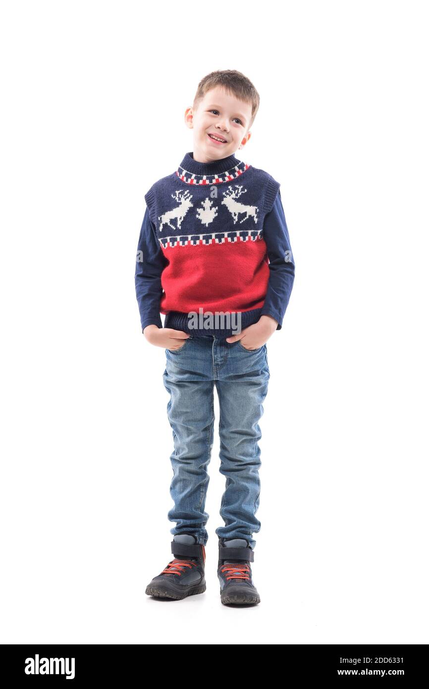 Mignon jeune garçon en gilet de Noël tricoté regardant en souriant avec les  mains dans les poches. Portrait du corps entier isolé sur fond blanc Photo  Stock - Alamy