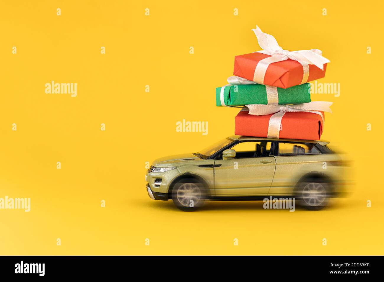 Modèle de voiture jaune flou avec des cadeaux de Noël sur fond jaune. Boîte  cadeau de livraison. Concept de livraison rapide cadeaux, Noël et cadeau de  Noël concept.Co Photo Stock - Alamy