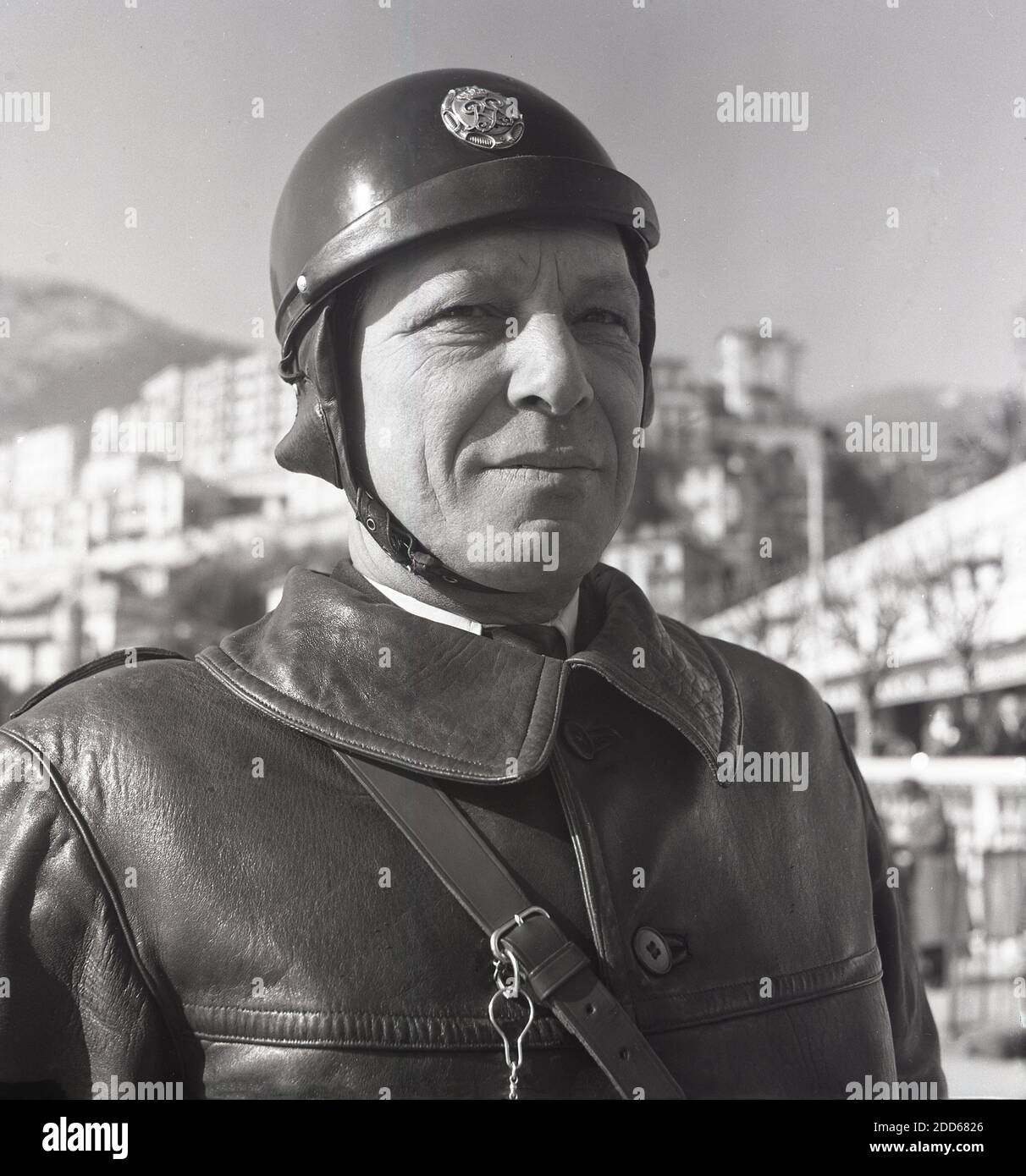 Années 1950, historique, Monte-Carlo, un gros plan de J Allan Cash d'un officier de police de moto Monaco dans sa veste en cuir épaisse, militaire dans le style et portant un casque rond de l'époque, avec le cuir sous la sangle. Banque D'Images